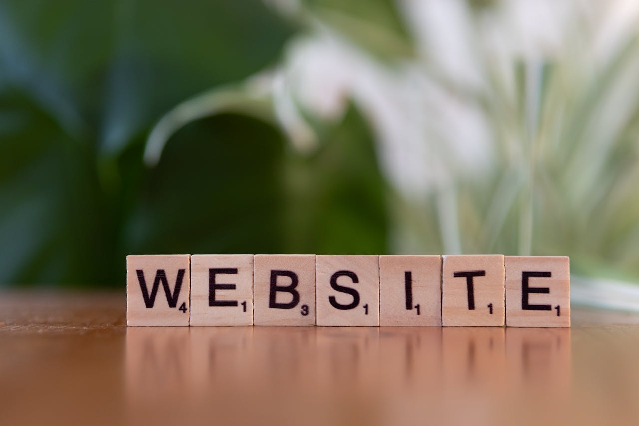 Scrabble tiles on a wooden surface forming the word Website, symbolizing digital communication.